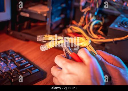 Cutting the Internet cable tied into a knot with wire cutters. The concept of disconnecting the Internet and restricting access to resources Stock Photo