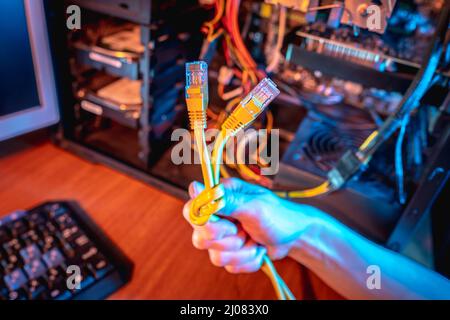The hand holds the Internet cable tied in a knot. The concept of disconnecting the Internet and restricting access to resources Stock Photo