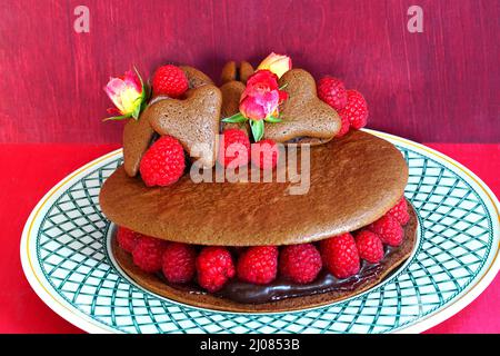 A giant chocolate macaron cake with fresh raspberries and rose flowers Stock Photo