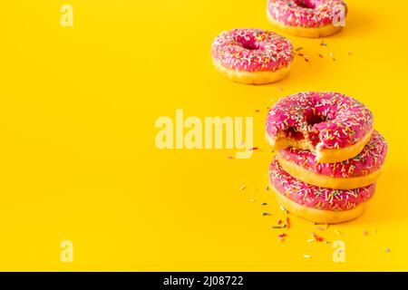 Close up of pink frosted donuts with colorful sprinkles Stock Photo