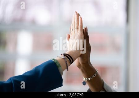 Two Smiling Young Businesswomen Giving High Five In Office Stock Photo