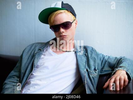 Urban attitude. Attractive young blond guy wearing street-style clothing and a smirk. Stock Photo