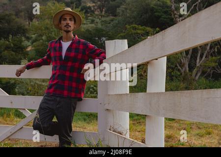 Male young black farmer working in front of the farmers gate. Stock Photo