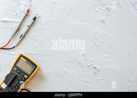 Yellow Digital multimeter with probes on white background with free copy space. Stock Photo