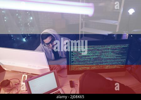 Russian hacker working in dark room Stock Photo