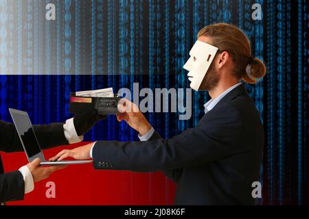 Russian hacker in mask stealing money from user Stock Photo