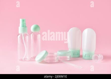 Set of empty travel cosmetic bottles and jars on pink background Stock Photo
