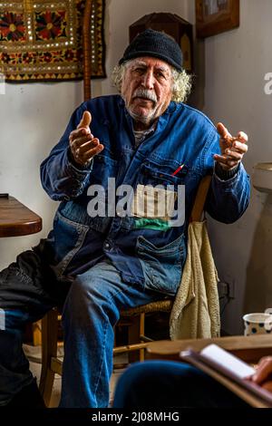An elderly man in a tool jacket is gesturing as he speaks in İsimsiz Yol, Büyükkonuk, TRNC Stock Photo