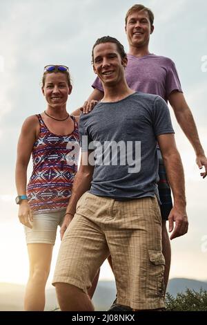 Finding happiness in hiking. Portrait of three happy friends posing together during a hike in the mountains. Stock Photo
