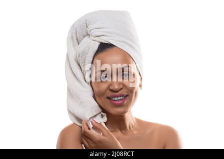 Smiley 35 years old african-american woman in terry towel on head - isolated on white background. She looking at camera and smiling. Stock Photo