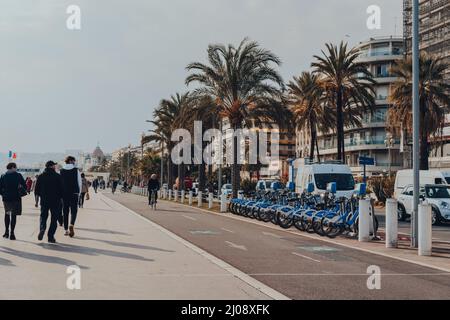 Nice, France - March 10, 2022: People walking along the cycle lane on The Promenade des Anglais in Nice, a famous tourist destination on the French Ri Stock Photo