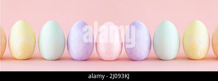 Pastel Easter eggs standing a row . Easter decoration on pink coloured background Stock Photo