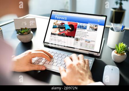 Reading Online News Media. Looking At Newspaper On Screen Stock Photo
