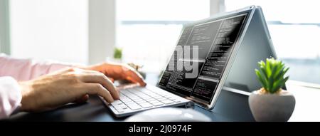 Male Software Developer Typing Code On Laptop Stock Photo