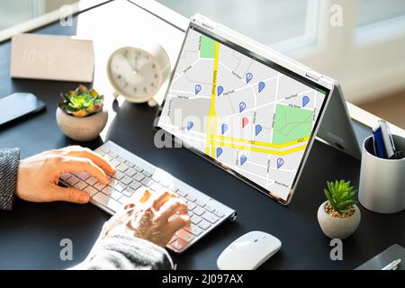Man Using GPS Map With Navigation Pointers On Laptop Stock Photo
