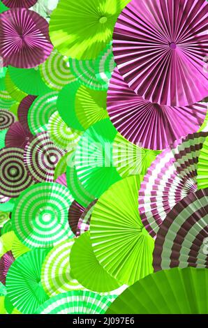 Layers of purple and lime green pleated paper decorative art in the sunlight Stock Photo