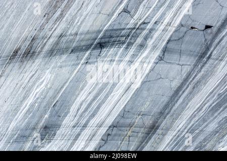 Surface of a cut of gray Karelian marble rock in Ruskeala in Karelia, for use as an abstract background and texture. Stock Photo