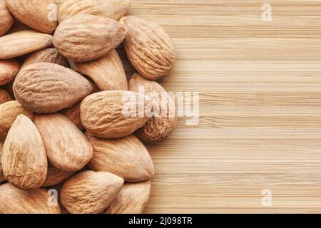 Close up picture of almonds on a wooden background, selective focus. Stock Photo