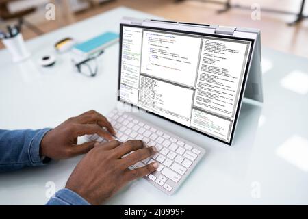 Programmer Or Coder At Office Desk Using Laptop Stock Photo