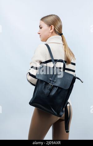 Black backpack on the shoulder of a woman, Women's backpack, gray women's backpack. Women's bag isolated on white background. The bag is isolated on a Stock Photo