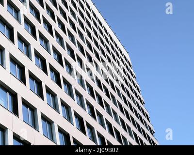 Modernist high-rise facade with repeating windows against a blue sky in Bratislava, Slovakia. Stock Photo
