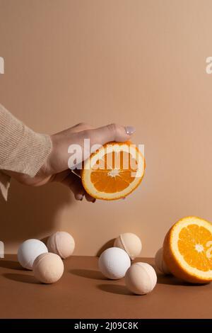 The organic bath bombs with bright orange on beige background. Space for text. Stock Photo