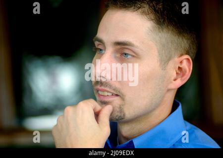 face of 30s Man with goatee and blue eyes at a family gathering with relatives and short hair Stock Photo