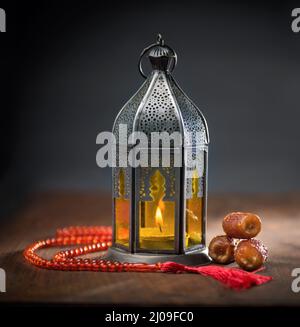 Ramadan lantern, dates and rosary still life. Traditional Egyptian Ramadan lamp with dates. Islamic religious objects and background. Stock Photo