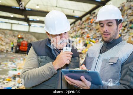 two caucasian workers communicating in recycling center Stock Photo