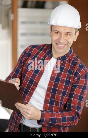 senior engineer wearing a safety-helmet and holding a clipboard Stock Photo