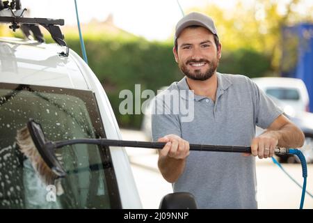 young man working on car cleaning Stock Photo