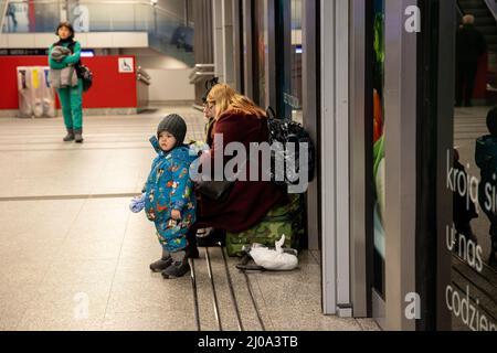 Krakow, Poland. 17th Mar, 2022. A young Ukrainian refugee is seen with his mother at the Krakow train station. As the second biggest city in Poland, Krakow is now hosting more than 100,000 Ukrainian refugees, accounting for 5% of the total number of Ukrainian refugees in Poland. Credit: SOPA Images Limited/Alamy Live News Stock Photo