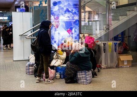 Krakow, Poland. 17th Mar, 2022. A Ukrainian refugee family is seen waiting at the Krakow train station. As the second biggest city in Poland, Krakow is now hosting more than 100,000 Ukrainian refugees, accounting for 5% of the total number of Ukrainian refugees in Poland. Credit: SOPA Images Limited/Alamy Live News Stock Photo