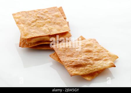 Deep Fried WOnton Sheet Isolated on White Background, Asian Popular Side Dish for Noodle or Wonton Soup, Isolated on White Stock Photo