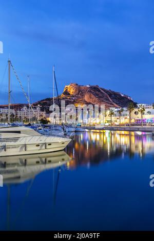 Alicante Port d'Alacant marina with boats and view of castle Castillo Mediterranean Sea twilight travel traveling holidays vacation portrait format in Stock Photo