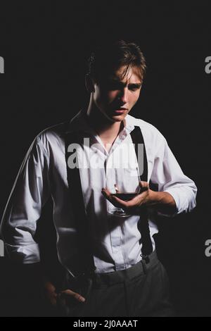 Man with glass brandy or cognac. Man holding a glass of whisky. Portrait of man with glass of whiskey isolated on black studio. Tasting and Stock Photo