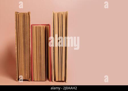 A stack of old worn books on a colored background Stock Photo