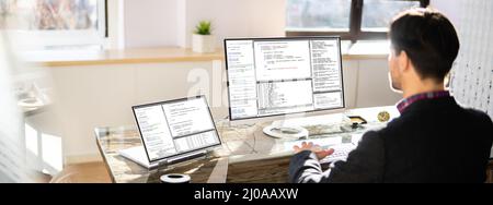 Computer Programmer Writing Program Code On Computer In Office Stock Photo