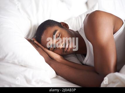 He could sleep the whole day away. Shot of a handsome young man sleeping at home. Stock Photo