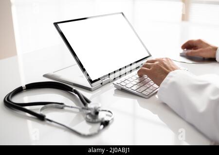 Midsection Of Male Doctor Using Laptop At Desk In Clinic Stock Photo
