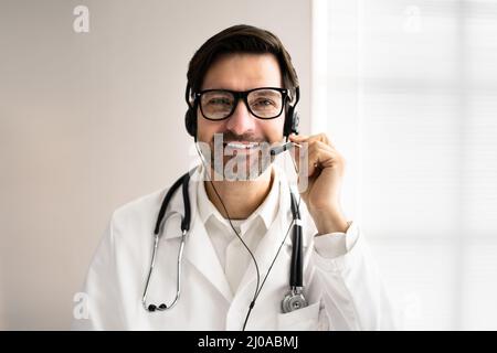 Close-up Portrait Of Confident Receptionist Using Headset In Hospital Stock Photo