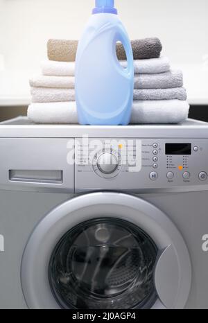 Your laundry will love it. Shot of a washing machine with folded towels and detergent on top of it. Stock Photo