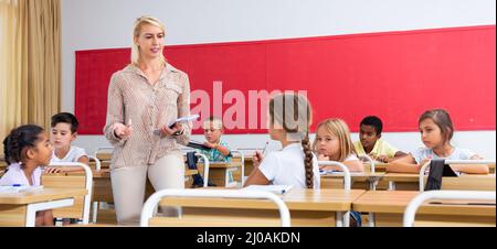 Teacher communicates freely with students in classroom at elementary ...