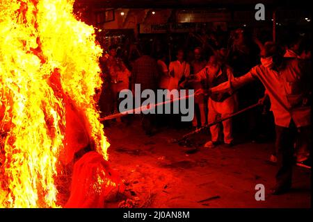 Rajasthan, India. 17th Mar, 2022. Indian People gather around the bonfire to offer prayers as they celebrate “Holika Dahan” in Pushkar, Rajasthan, India on March 17, 2022 . Holika Dahan, or burning of demon Holika, is celebrated the night before the Holi festival and is said to commemorate the escape of Prahlad (devotee of lord Vishnu) from being burned when carried by Demoness Holika into fire. The bonfire symbolises the victory of good over evil. Photo by ABACAPRESS.COM Credit: Abaca Press/Alamy Live News Stock Photo