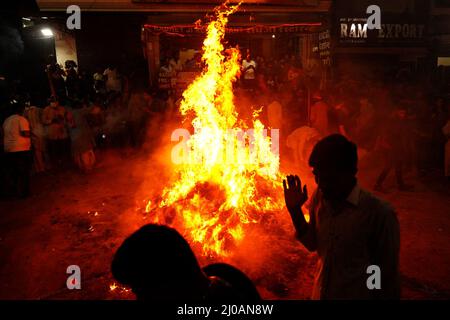 Rajasthan, India. 17th Mar, 2022. Indian People gather around the bonfire to offer prayers as they celebrate “Holika Dahan” in Pushkar, Rajasthan, India on March 17, 2022 . Holika Dahan, or burning of demon Holika, is celebrated the night before the Holi festival and is said to commemorate the escape of Prahlad (devotee of lord Vishnu) from being burned when carried by Demoness Holika into fire. The bonfire symbolises the victory of good over evil. Photo by ABACAPRESS.COM Credit: Abaca Press/Alamy Live News Stock Photo
