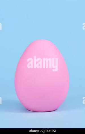 Single pink easter egg on blue background Stock Photo