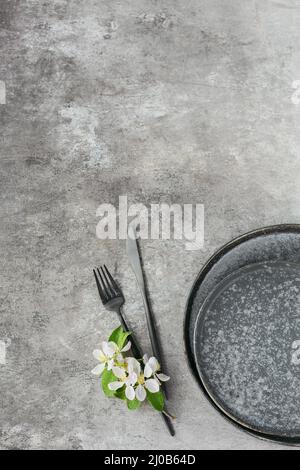 Spring place table setting with blossoming apple tree branches and flowers on grey table. Holidays decoration on Provence style. Romantic dinner. Over Stock Photo