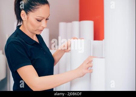 Young woman working in printing factory. Printing tools Stock Photo