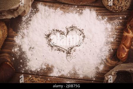 Different types of bread on wooden table dusted with flour. Top view Stock Photo