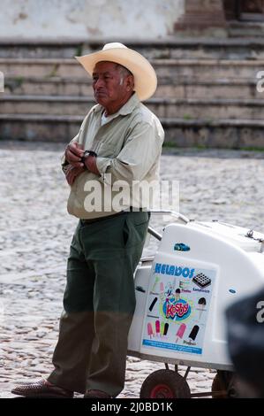 Man with cowboy hat Leaning On An Ice cream Cart on the street Stock Photo